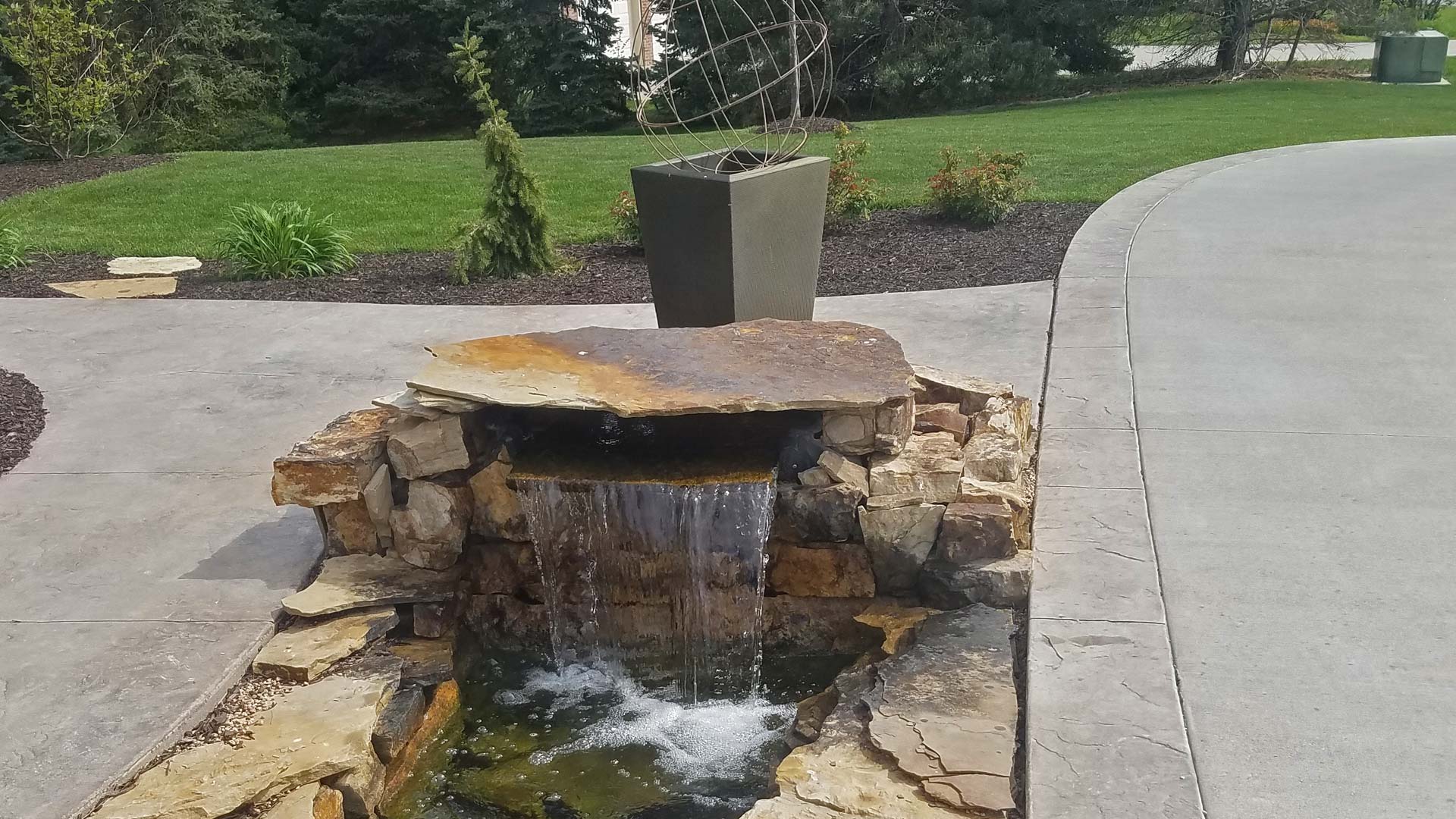 Water fountain feature and new landscaping installed at a property in Lincoln, NE.