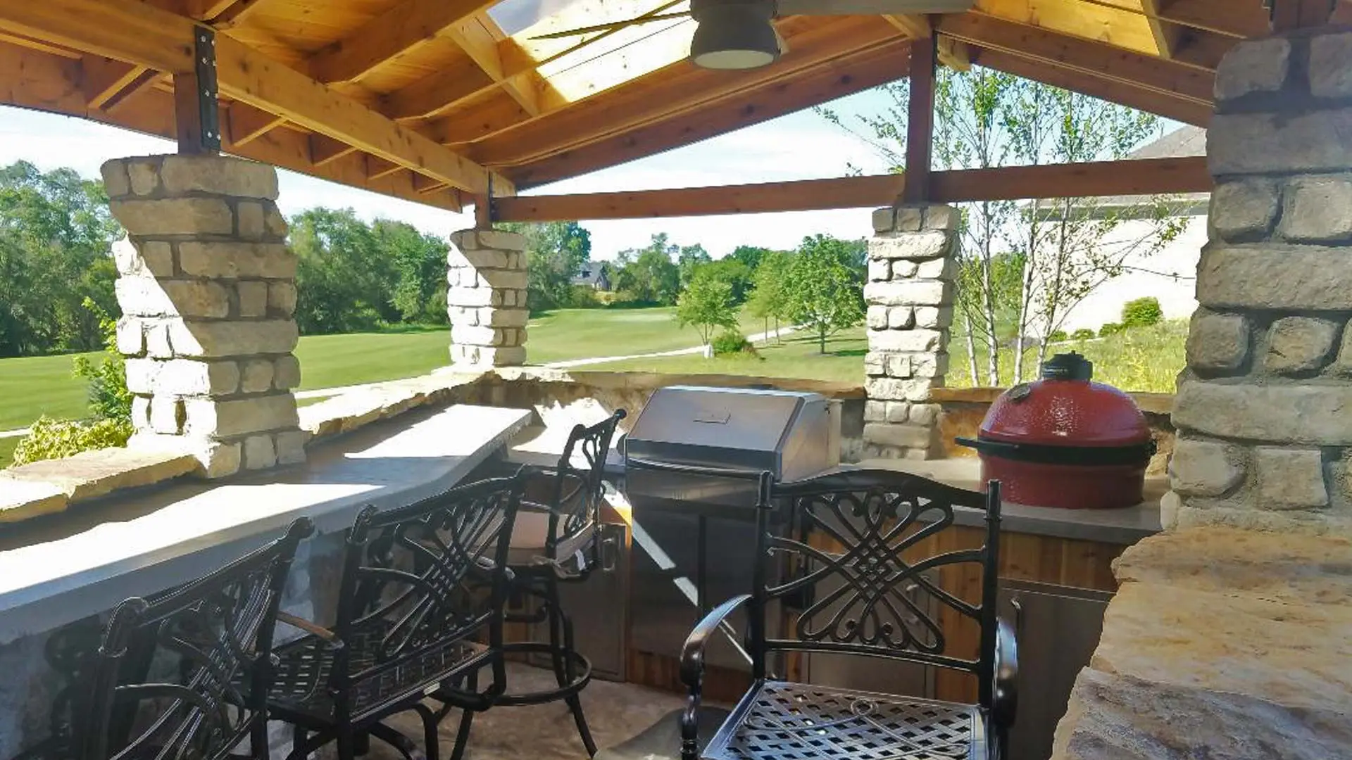 Outdoor kitchen with a built in grill, bar, and smoker.