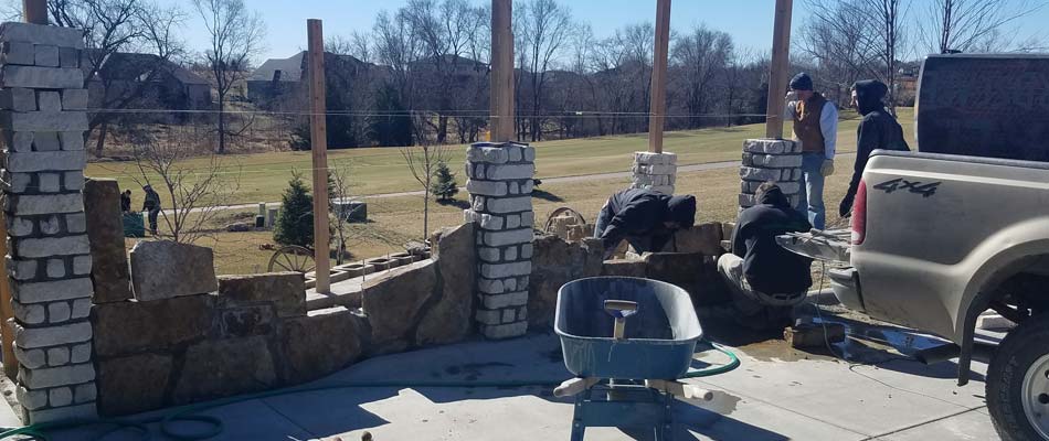 Our team constructing a wall for one of our outdoor kitchen hardscaping projects in Lincoln. 